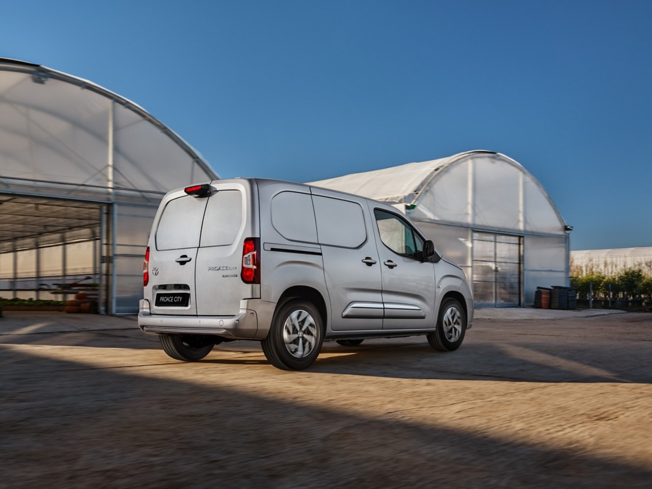 A Toyota Proace drives a long country road