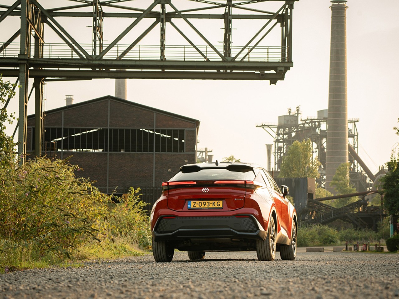 Toyota C-HR, exterieur, achterzijde, rijdend, industrieel gebied, fabriek