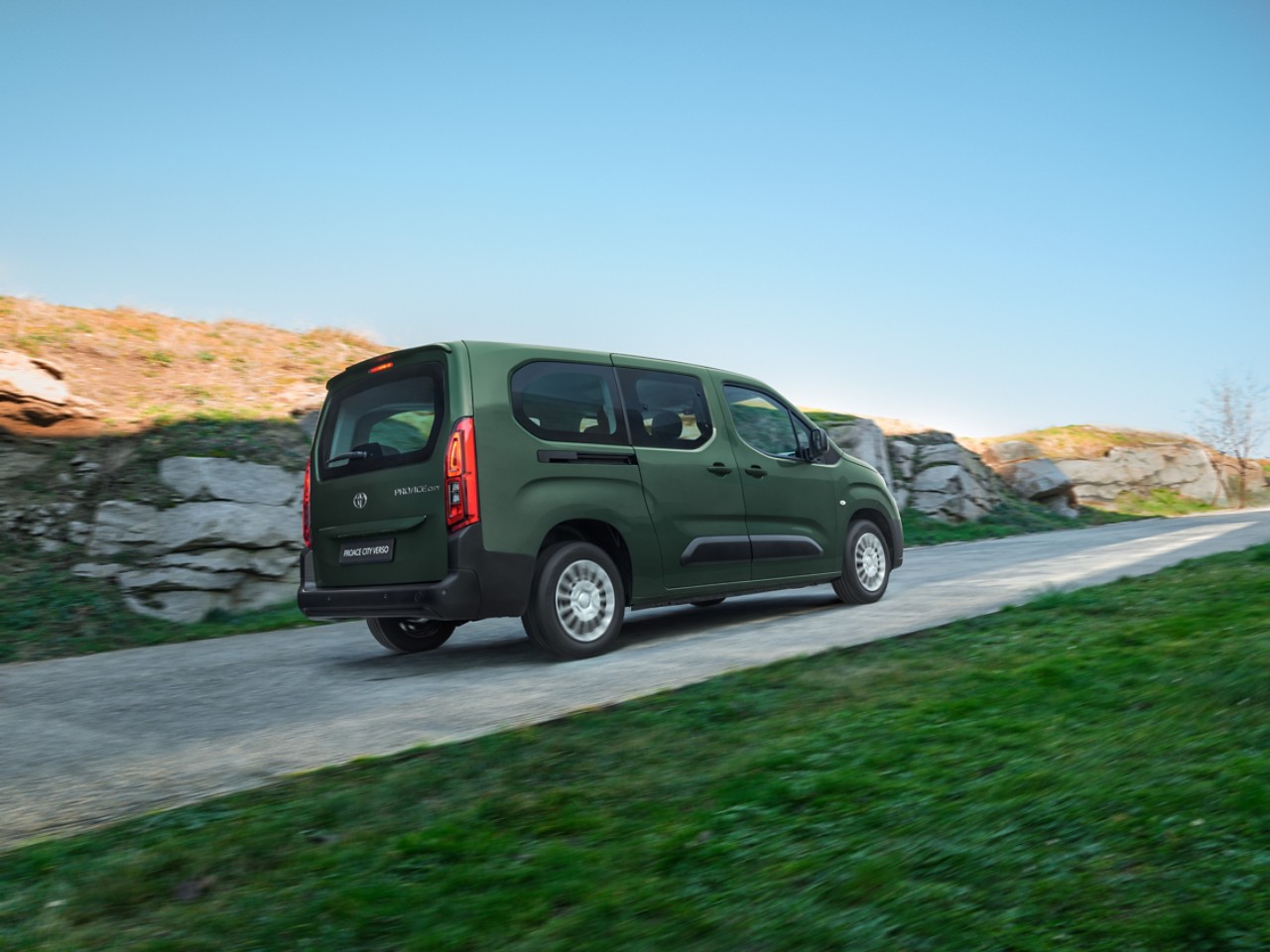 A Toyota Proace drives a long country road